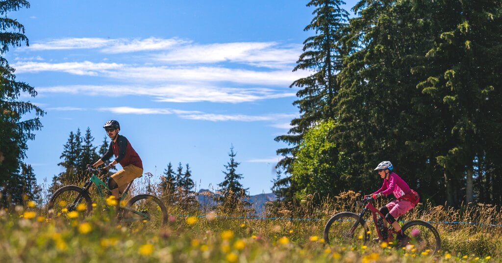 Homme et femme en VTT à Morzine, jolies prairies